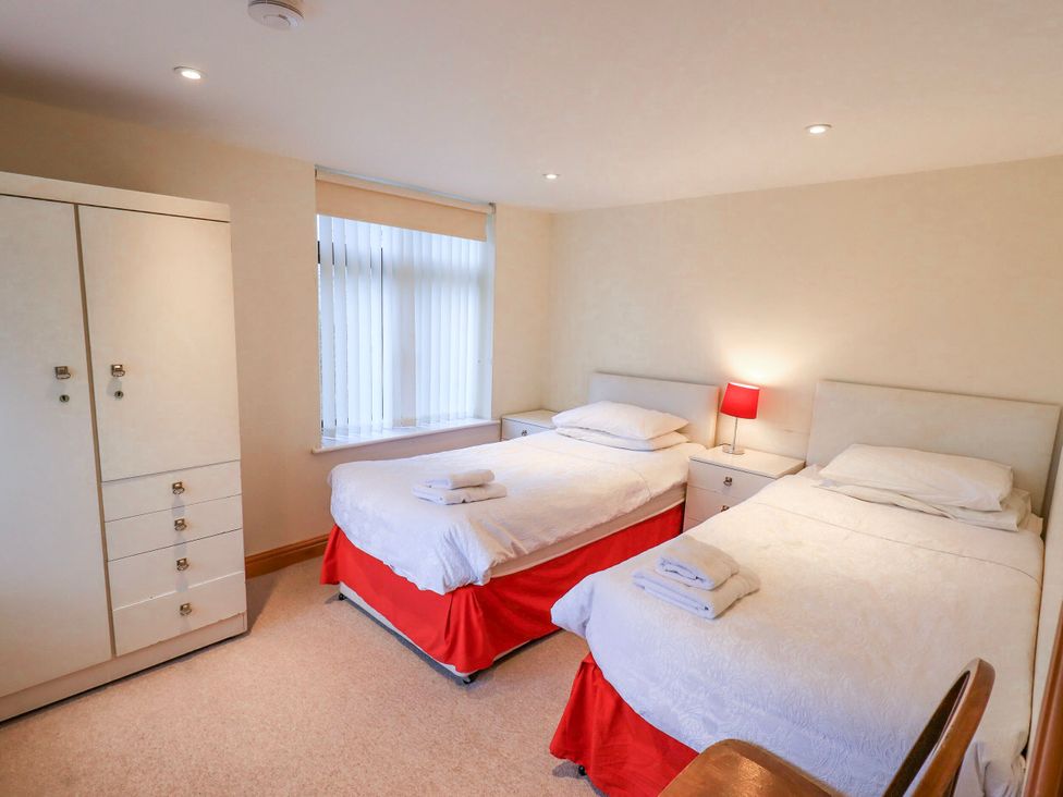 A bedroom with two beds and a dresser at Ghyll Bank House in Staveley near Windermere