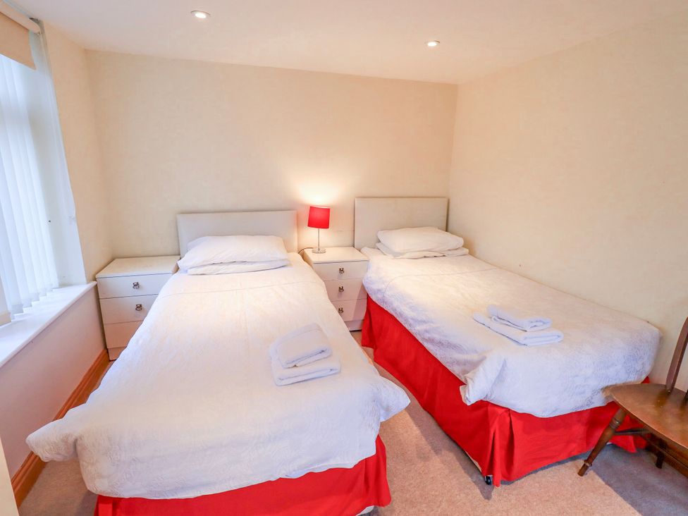 A bedroom with twin beds and a bedside table at Ghyll Bank House Staveley near Windermere