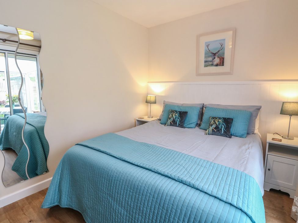 A bedroom with a bed and bedside tables at Steam Cottage in Aviemore