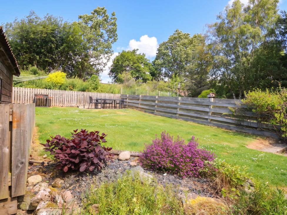 A garden with plants and a table at Steam Cottage in Aviemore
