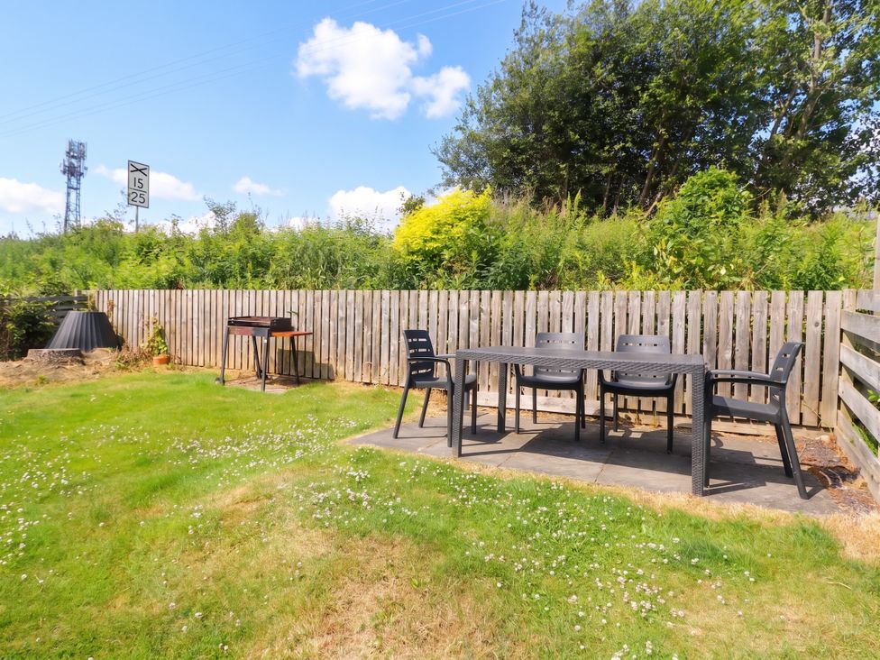 A garden with a table and chairs at Steam Cottage in Aviemore
