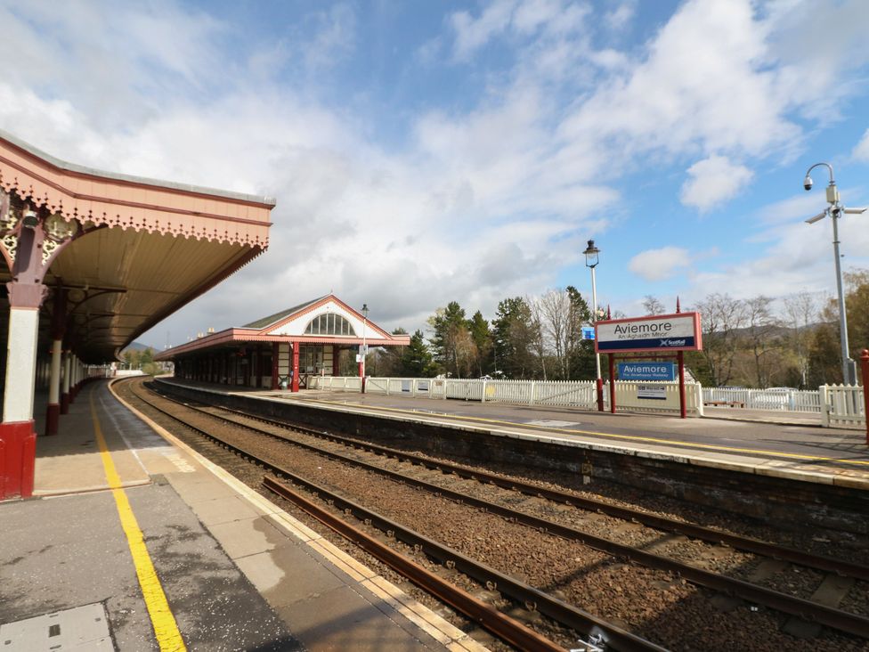 A train station with a platform and sign at Steam Cottage in Aviemore