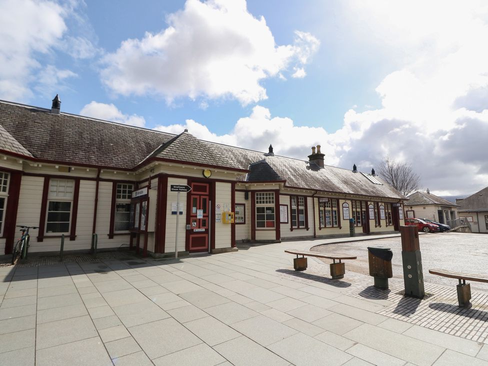 An exterior view of a building with benches and bicycle parking at Steam Cottage in Aviemore