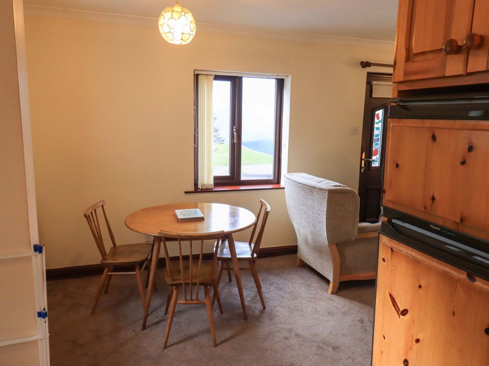 A dining room with a table and chairs at Ghyll Bank Bungalow Staveley near Windermere