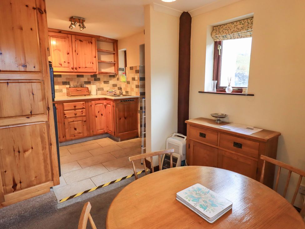 A dining room with a table and chairs at Ghyll Bank Bungalow Staveley near Windermere