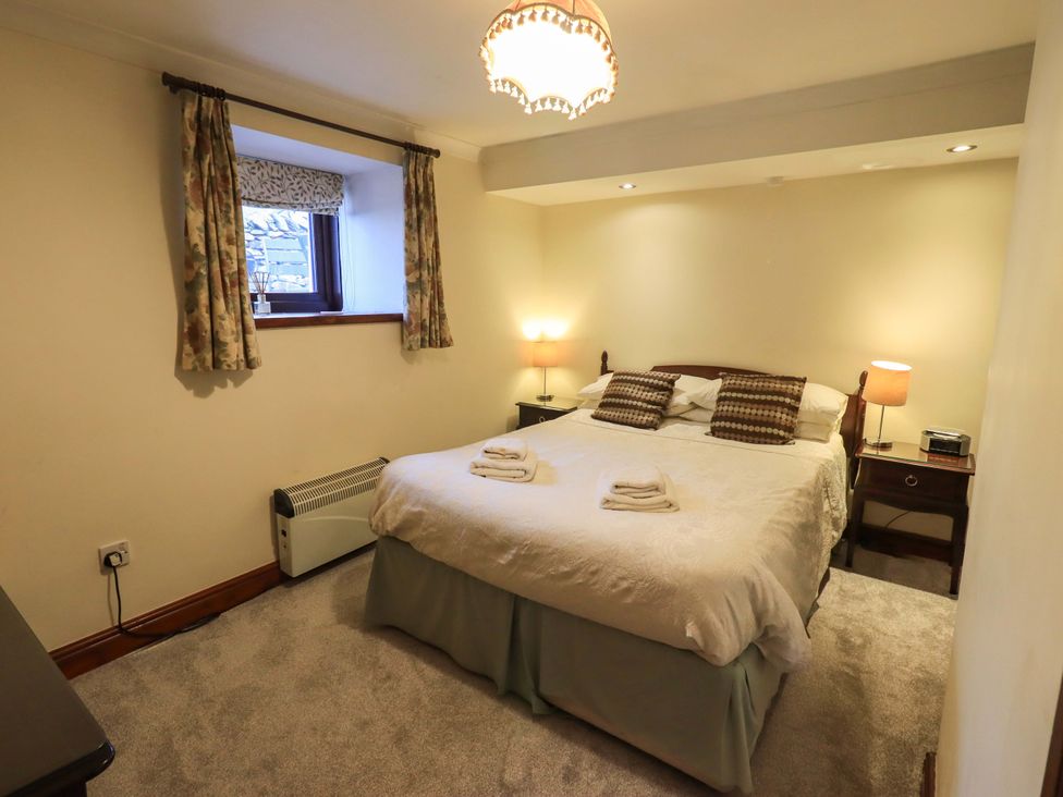 A bedroom with a bed and bedside table at Ghyll Bank Bungalow Staveley near Windermere