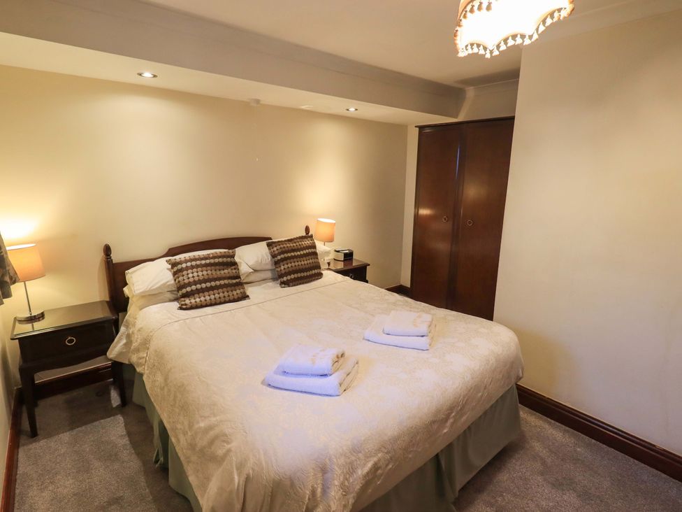 A bedroom with a bed and bedside table at Ghyll Bank Bungalow Staveley near Windermere