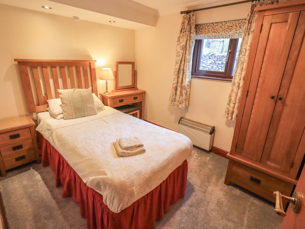 A bedroom with a bed and nightstand at Ghyll Bank Bungalow Staveley near Windermere