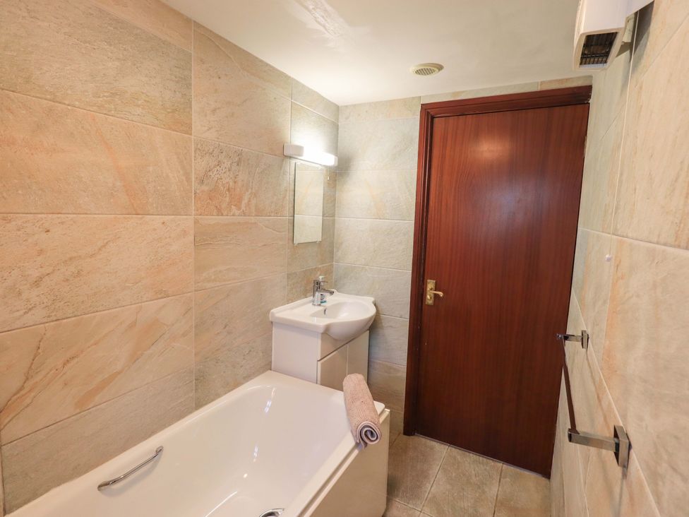 A bathroom with a bathtub and sink at Ghyll Bank Bungalow Staveley near Windermere