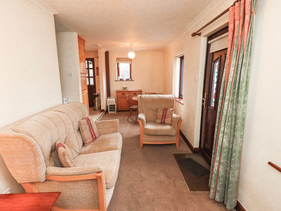 A living room with a sofa and armchair at Ghyll Bank Bungalow Staveley near Windermere
