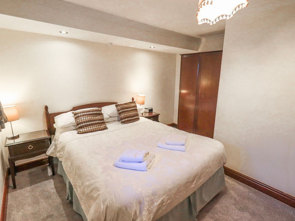 A bedroom with a bed and nightstands at Ghyll Bank Bungalow Staveley near Windermere