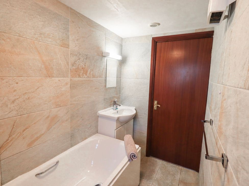 A bathroom with a bathtub and sink at Ghyll Bank Bungalow Staveley near Windermere