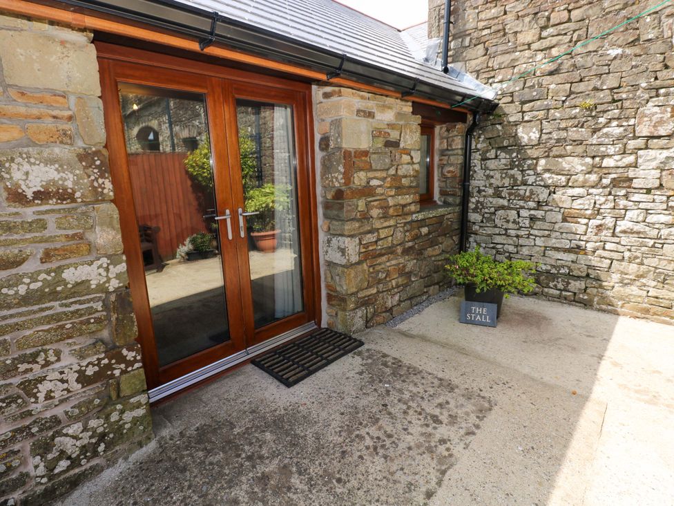 An outdoor area with a wooden door and stone walls at The Stall in Penuel near Llanmorlais