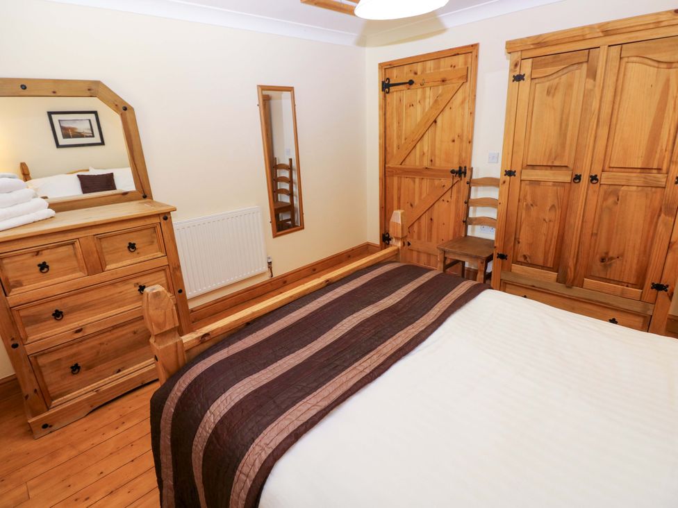 A bedroom with a bed, dresser, and wardrobe at The Stall in Penuel near Llanmorlais
