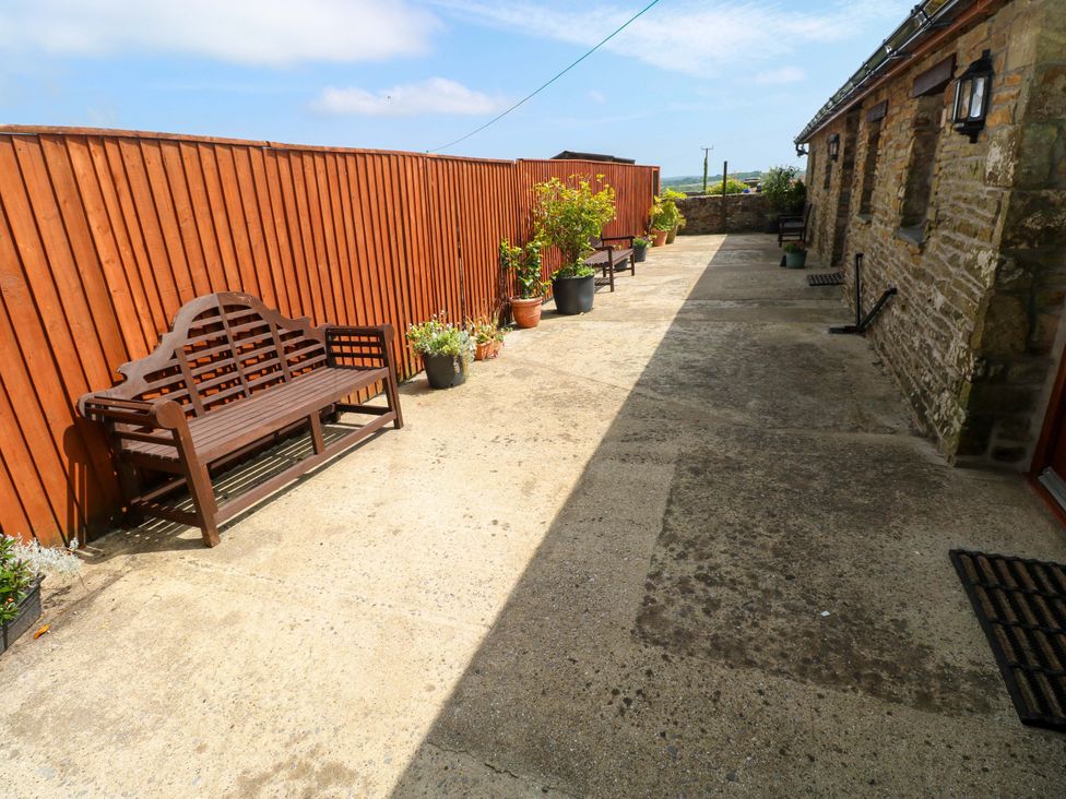An outdoor area with benches and planters at The Stall in Penuel near Llanmorlais