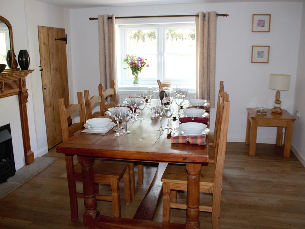 A dining room with a table set for dinner at Manor Farm Cottage Swaffham