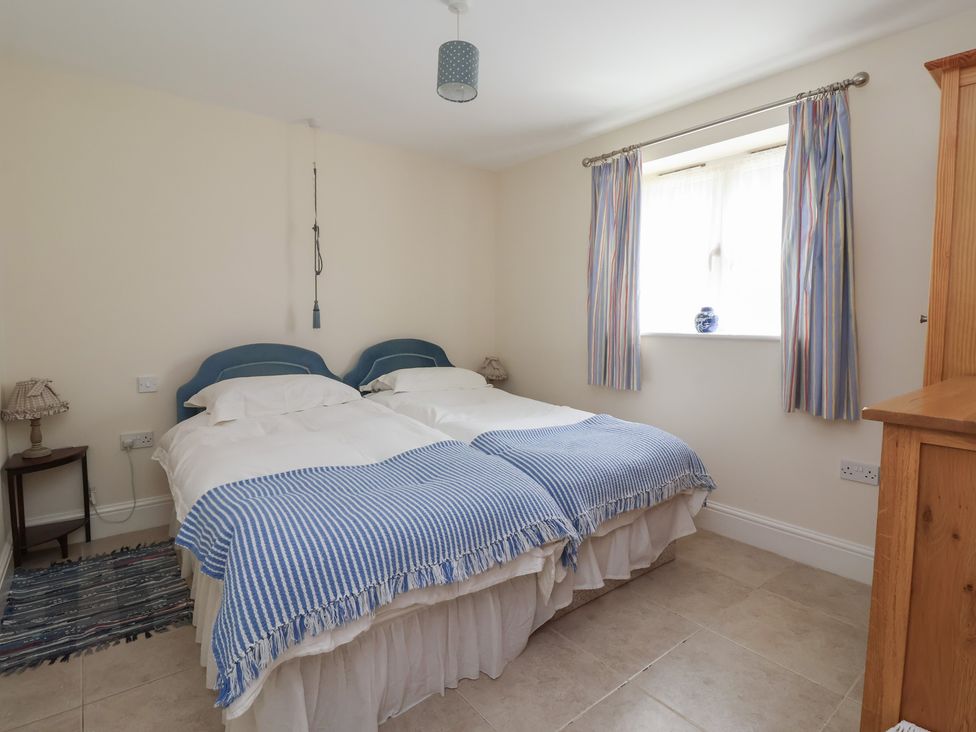 A bedroom with twin beds and a wardrobe at Stable Cottage Cawton near Hovingham