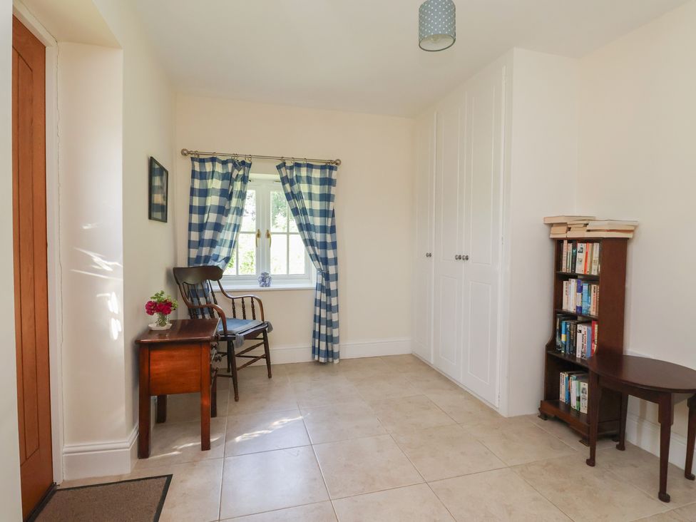 A hallway with a chair and table at Stable Cottage in Cawton near Hovingham