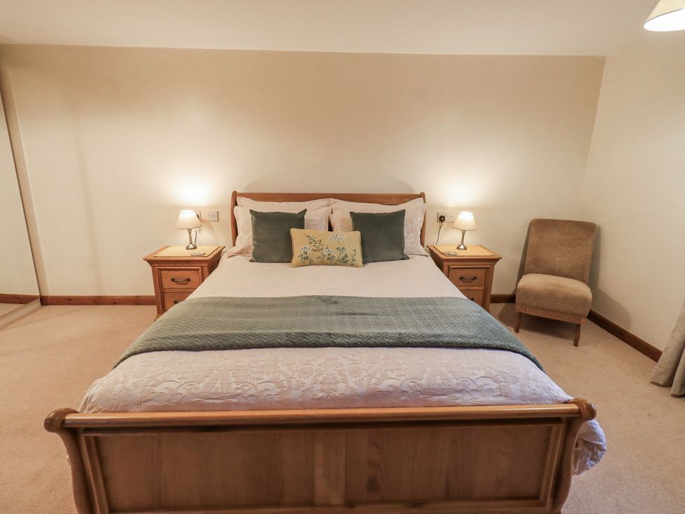 A bedroom with a bed and nightstands at Christine's Stable, Shap near Maulds Meaburn