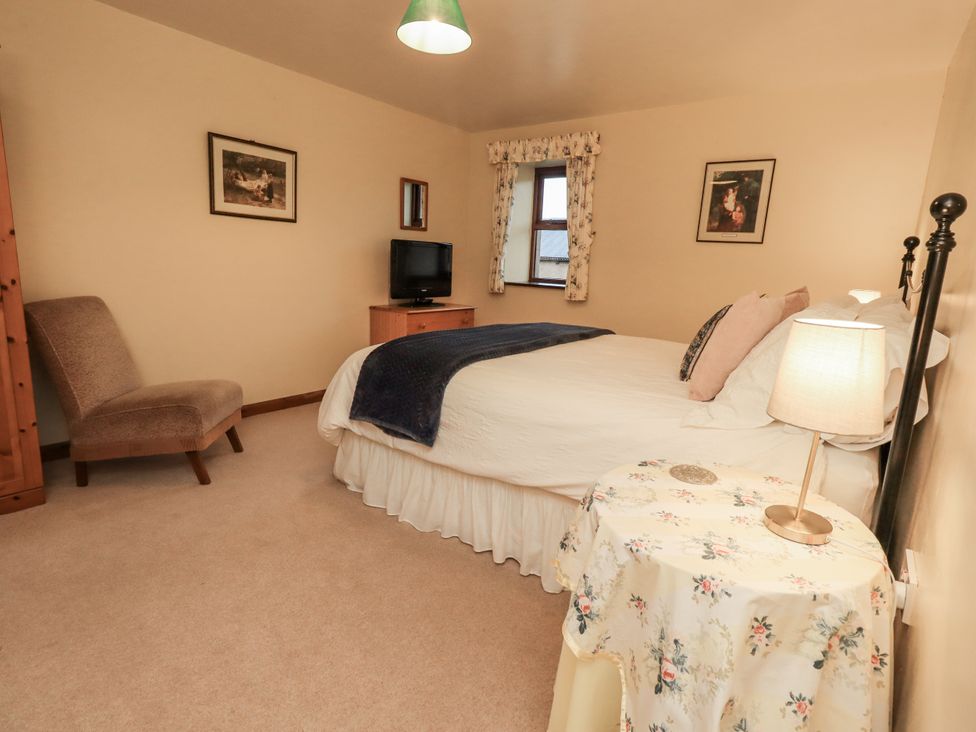 A bedroom with a bed and armchair at Christine's Stable in Shap near Maulds Meaburn