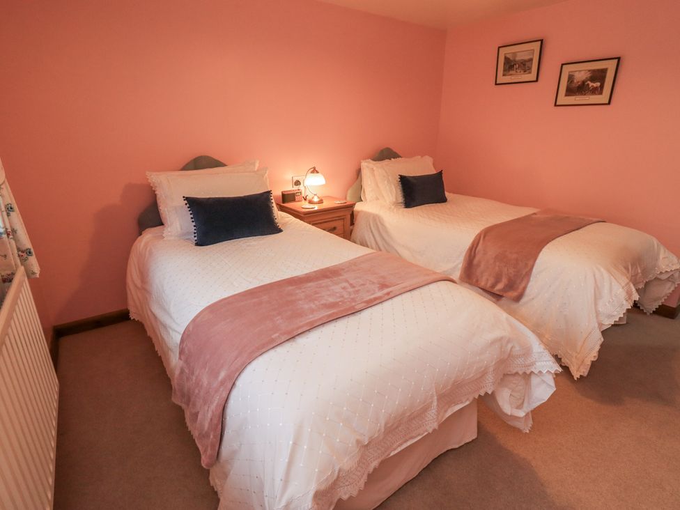A bedroom with two single beds and a bedside table at Christine's Stable Shap near Maulds Meaburn
