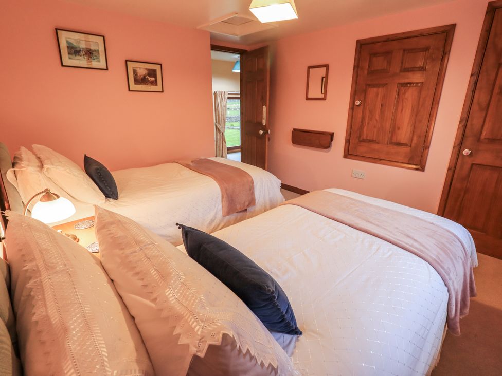 A bedroom with two beds and a window at Christine's Stable in Shap near Maulds Meaburn