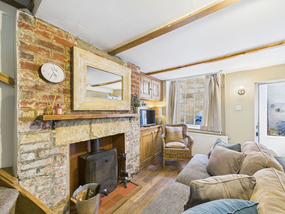 A living room with a fireplace and sofa at Delft Cottage in Robin Hood's Bay