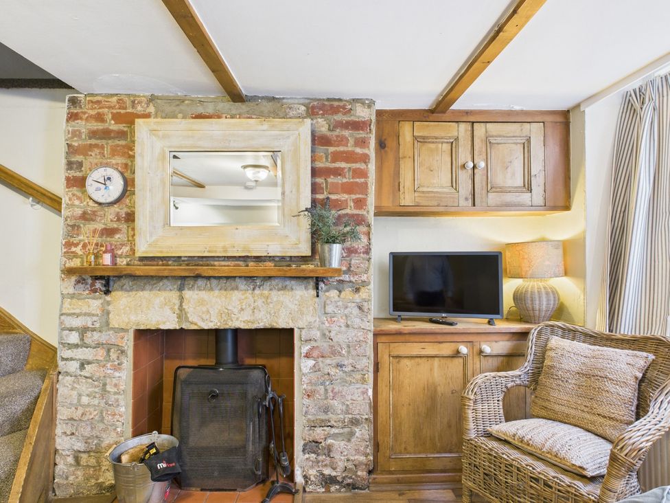 A living room with a fireplace and television at Delft Cottage Robin Hood's Bay