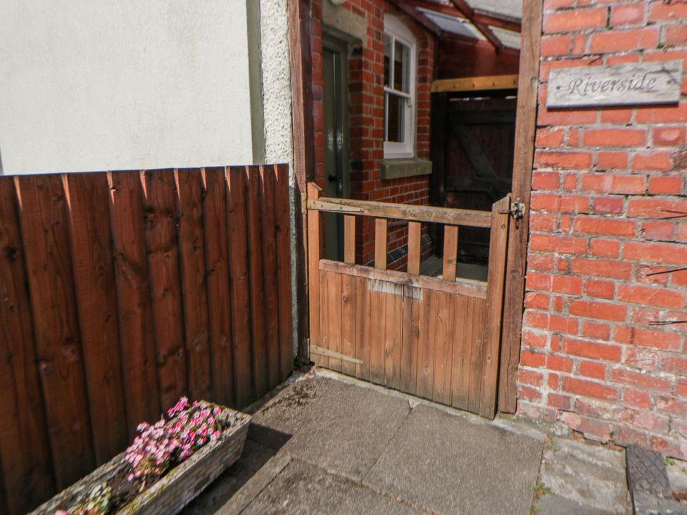 An outdoor area with a wooden gate and flower box at Riverside Cottage Llanwrthwl near Rhayader