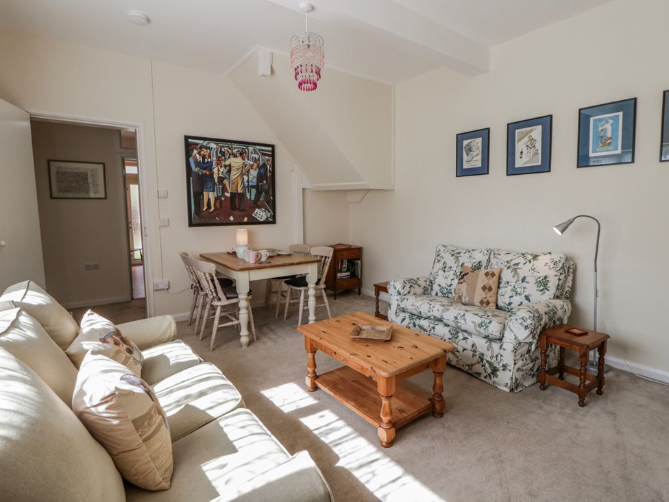 A living room with sofa and dining table at Riverside Cottage Llanwrthwl near Rhayader