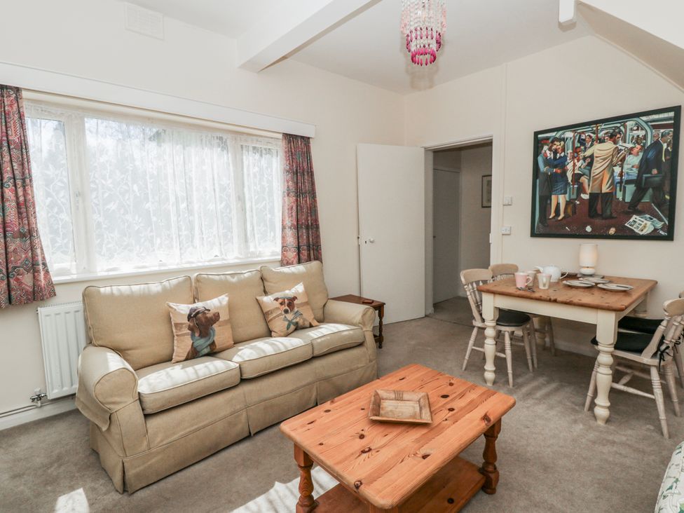 A living room with a sofa and dining table at Riverside Cottage near Llanwrthwl near Rhayader