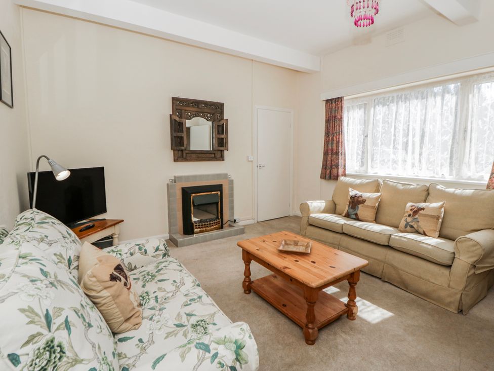 A living room with a sofa and television at Riverside Cottage Llanwrthwl near Rhayader