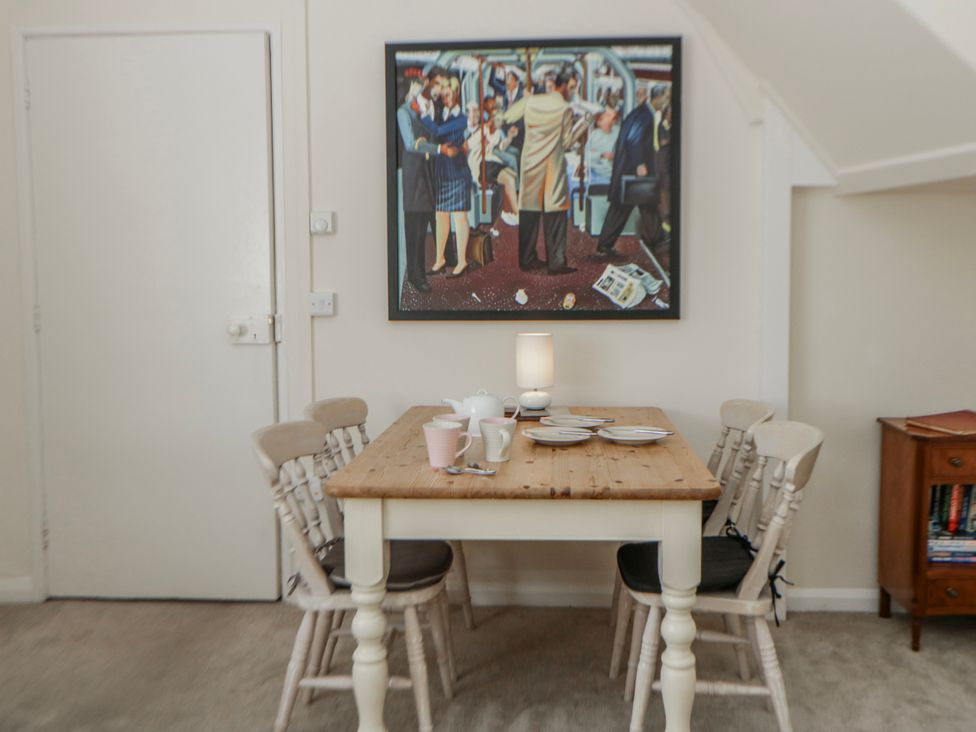 A dining room with a table and chairs at Riverside Cottage Llanwrthwl near Rhayader