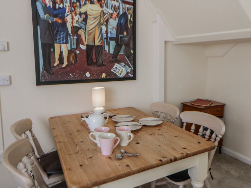 A dining room with a wooden table and chairs at Riverside Cottage Llanwrthwl near Rhayader