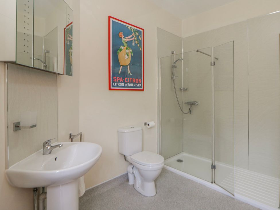 A bathroom with a sink, toilet, and shower at Riverside Cottage Llanwrthwl near Rhayader