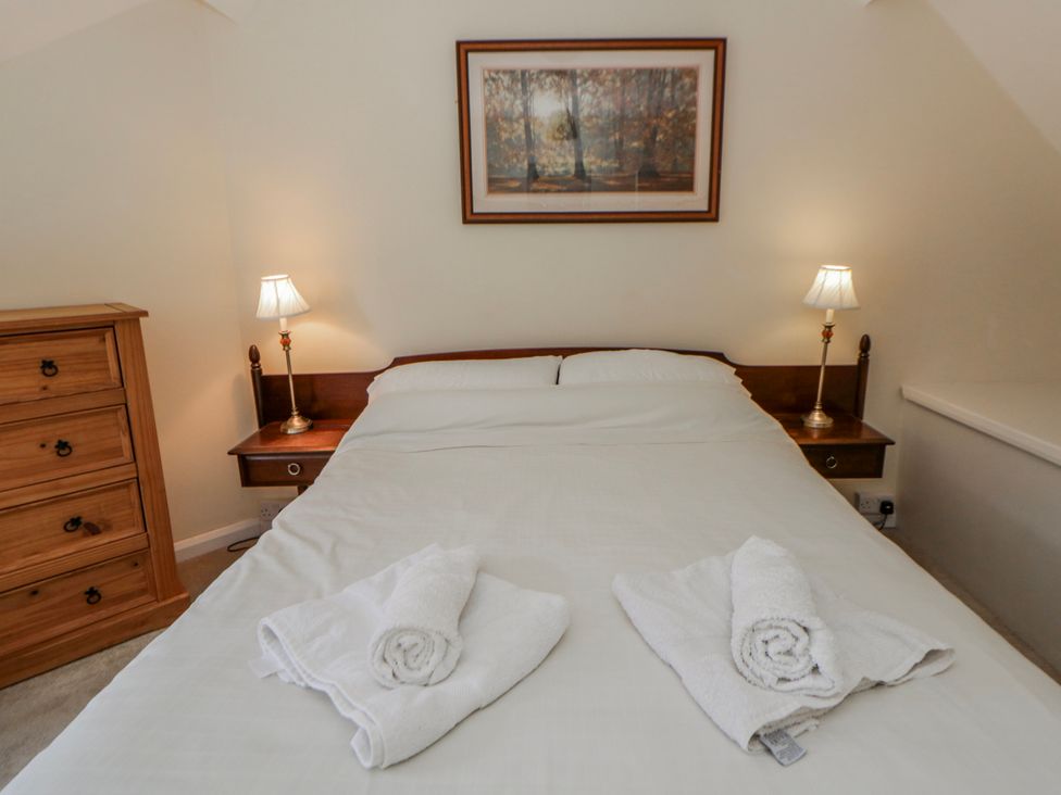 A bedroom with a bed and a dresser at Riverside Cottage Llanwrthwl near Rhayader