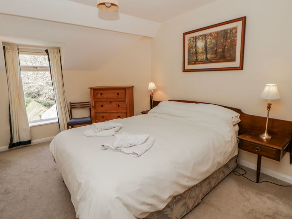 A bedroom with a bed and nightstand at Riverside Cottage Llanwrthwl near Rhayader