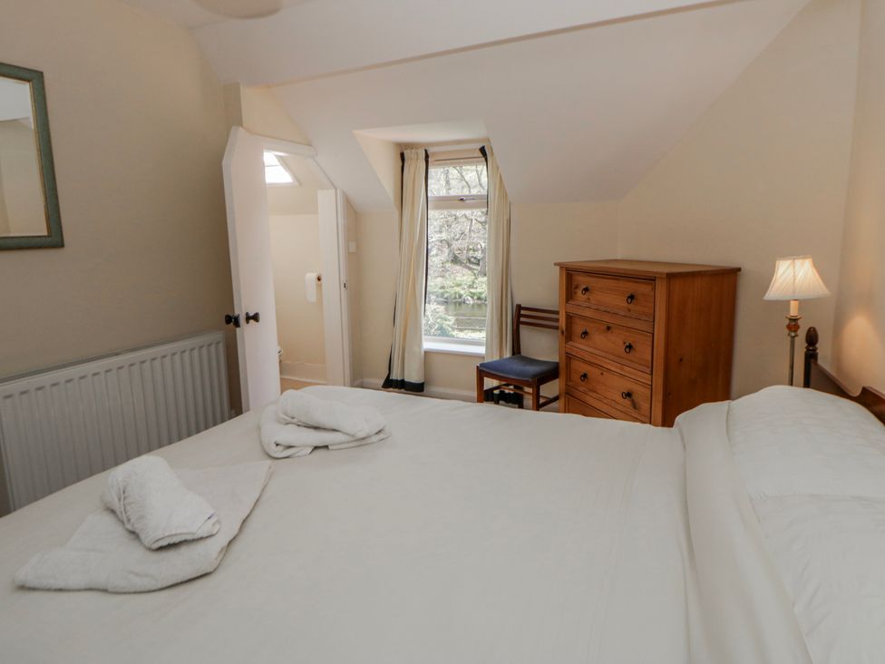 A bedroom with a bed and dresser at Riverside Cottage in Llanwrthwl near Rhayader