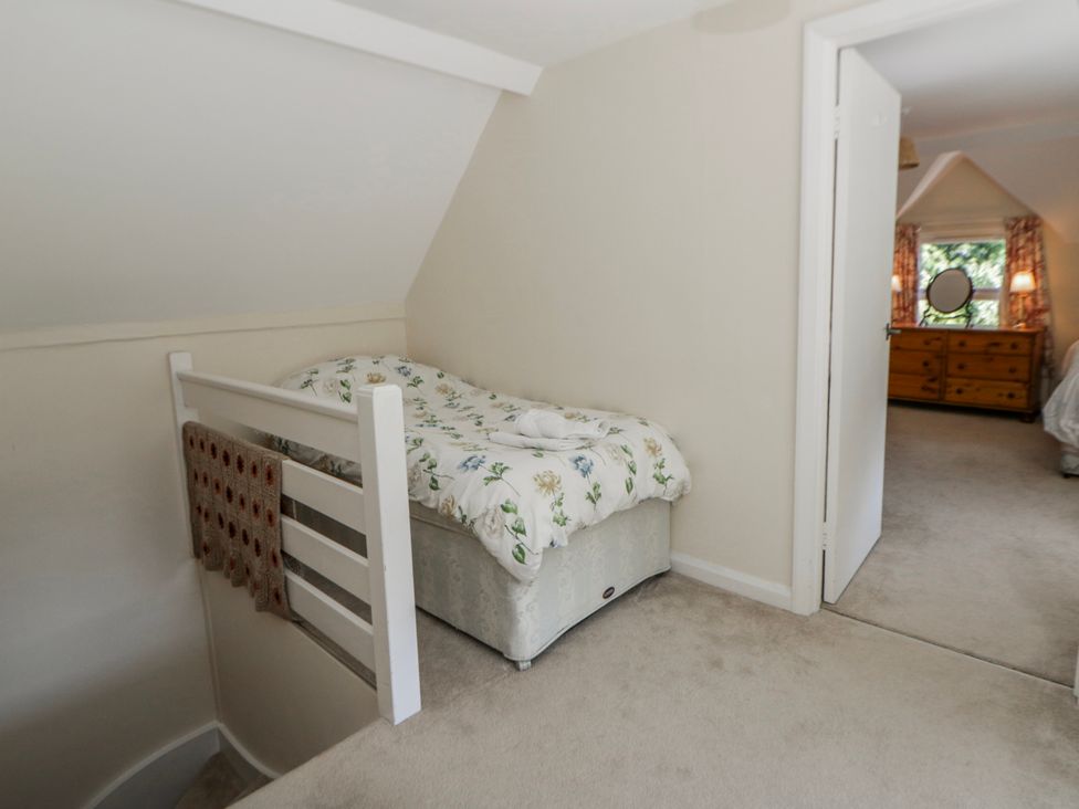 A bedroom with a bed and dresser at Riverside Cottage in Llanwrthwl near Rhayader