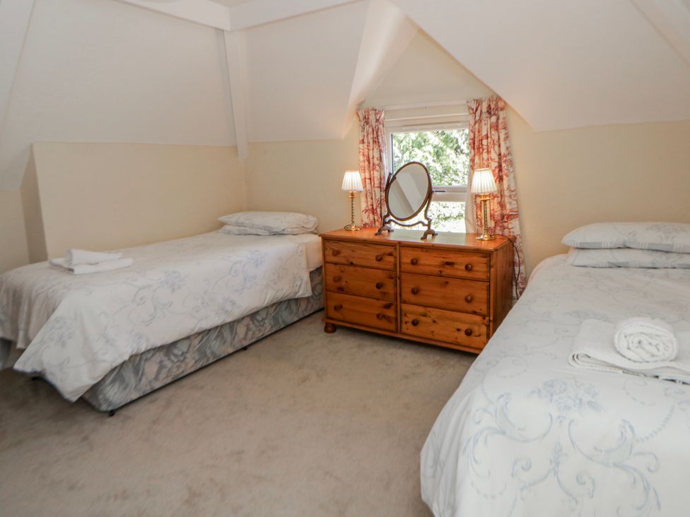 A bedroom with two single beds and a dresser at Riverside Cottage Llanwrthwl near Rhayader