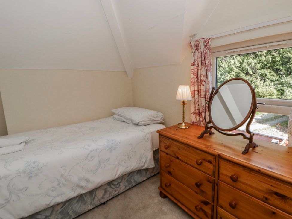 A bedroom with a bed and dressing table at Riverside Cottage Llanwrthwl near Rhayader