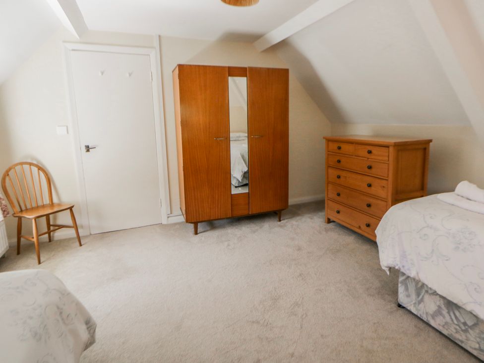 A bedroom with a wardrobe and a chest of drawers at Riverside Cottage in Llanwrthwl near Rhayader