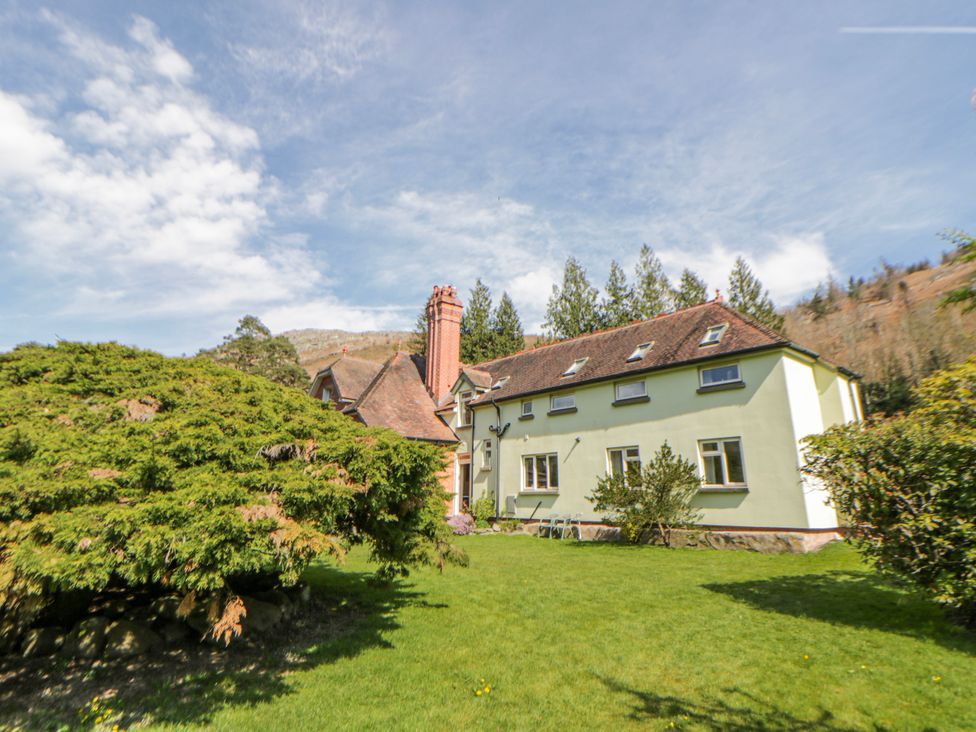 A house with bushes in front at Riverside Cottage Llanwrthwl near Rhayader