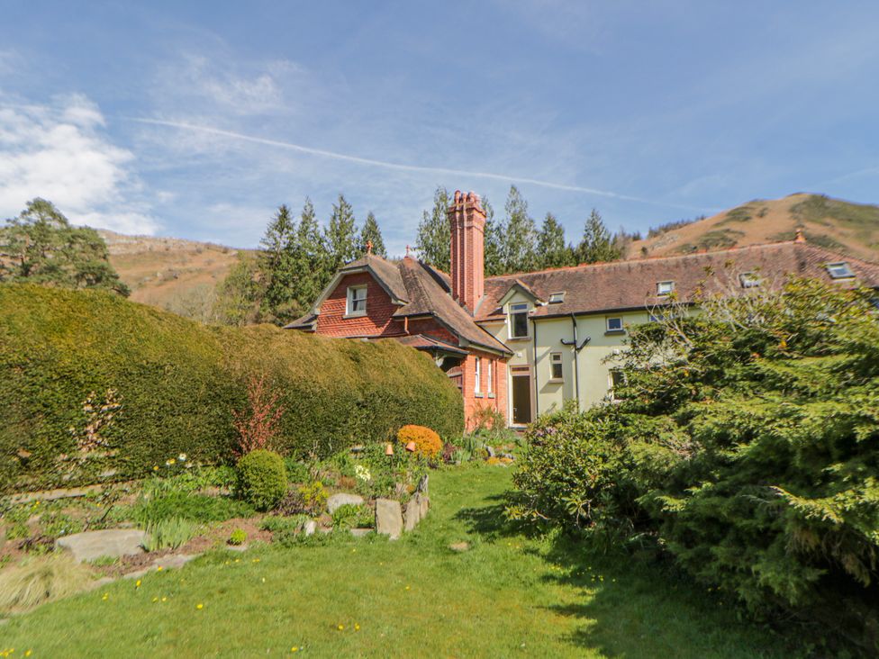 A house with a chimney and garden at Riverside Cottage Llanwrthwl near Rhayader