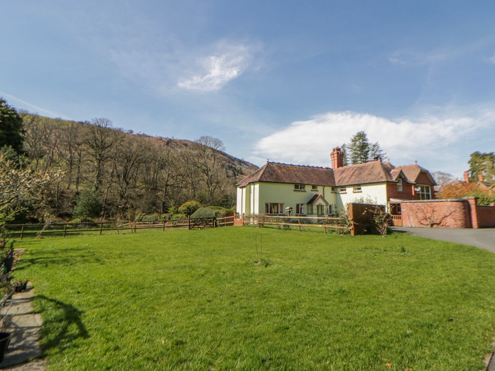 A house with a garden and trees at Riverside Cottage in Llanwrthwl near Rhayader