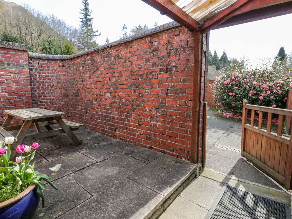 A garden with a table and flowers at Riverside Cottage in Llanwrthwl near Rhayader