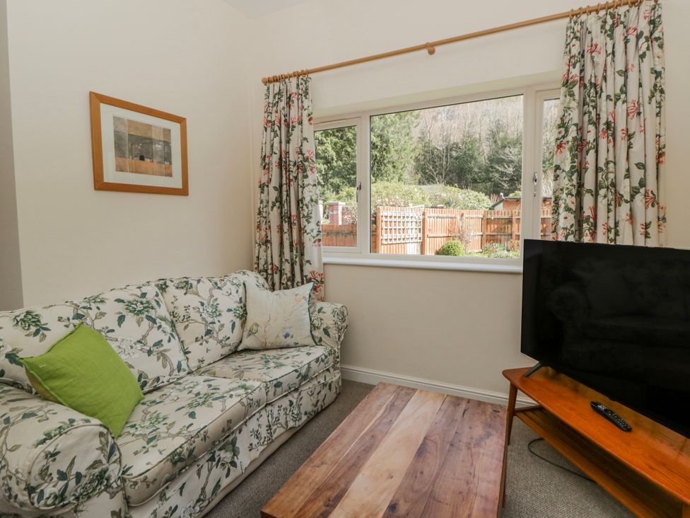 A living room with a sofa and television at Gardener's Cottage, Llanwrthwl near Rhayader