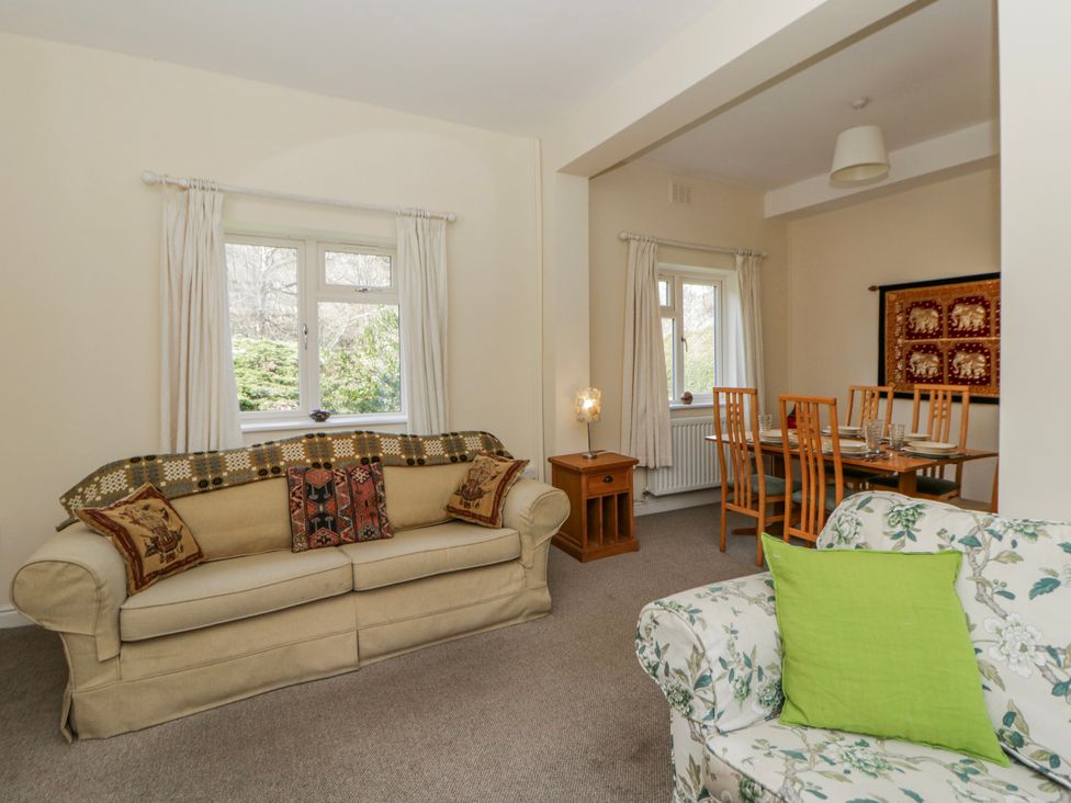 A living room with a sofa and dining table at Gardener's Cottage in Llanwrthwl near Rhayader