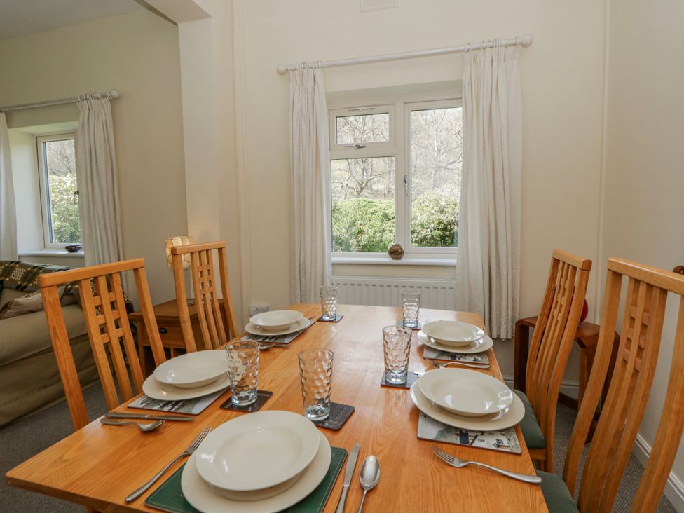 A dining room with a table set for a meal at Gardener's Cottage in Llanwrthwl near Rhayader