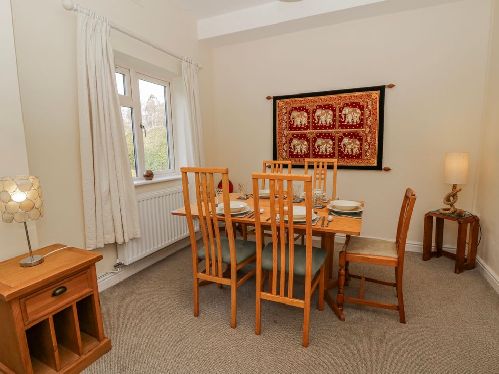 A dining room with a table set for dinner at Gardener's Cottage in Llanwrthwl near Rhayader